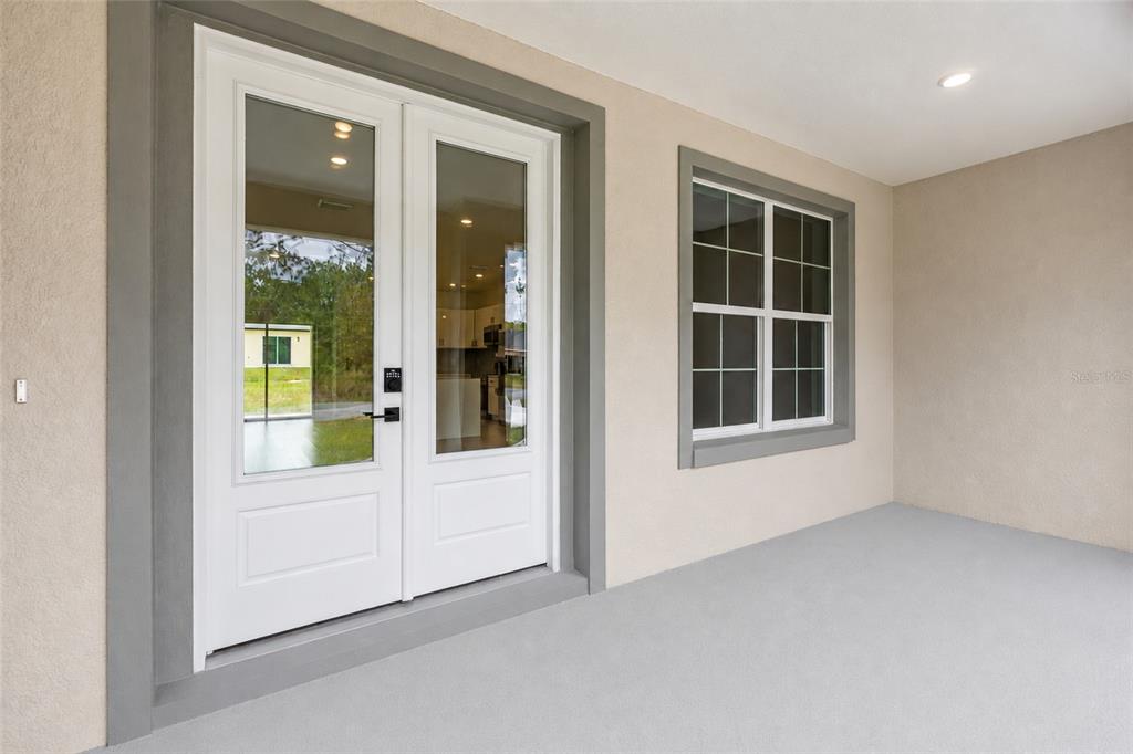 A covered patio features a white double glass door and a single window with grids — 7295 N GLENRIDGE CIRCLE, CITRUS SPRINGS, FL