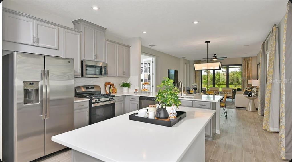 A kitchen with grey cabinets, stainless steel appliances, and a white island countertop — 737 STEEL DRIVE, APOLLO BEACH, FL