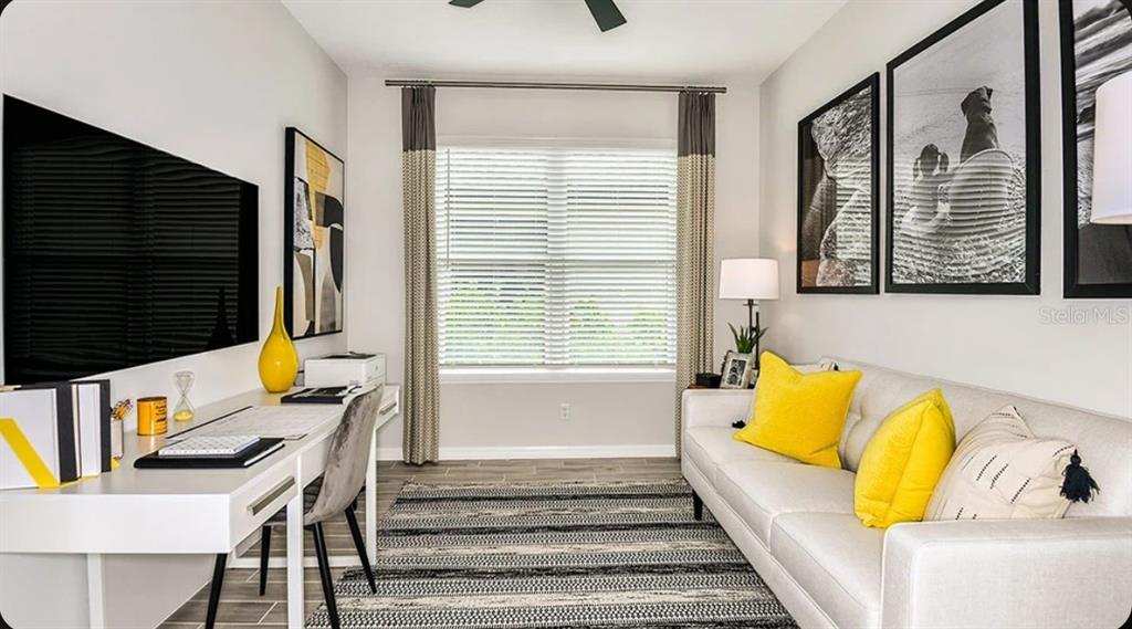 A home office features a white desk, a sofa with yellow pillows, and a window — 737 STEEL DRIVE, APOLLO BEACH, FL