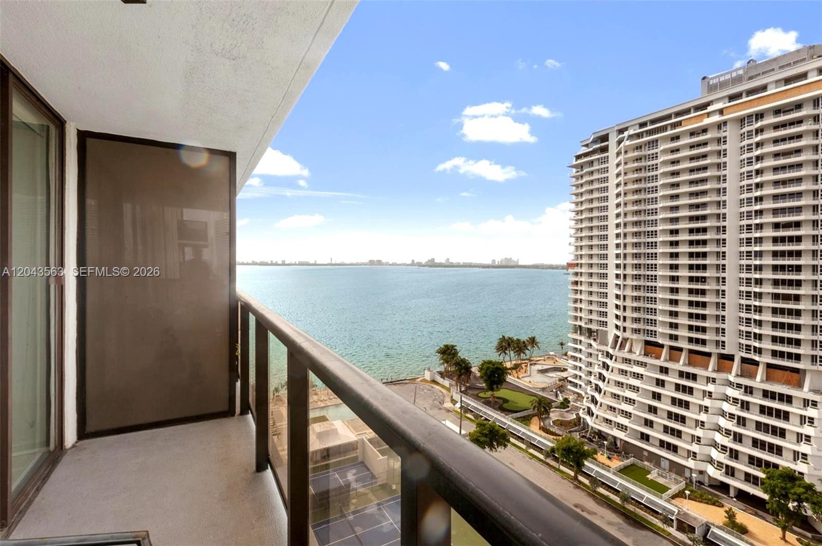 A balcony view overlooking the ocean and a high-rise building — 600 NE 36th St # 1717, Miami FL 33137, MIAMI, FL