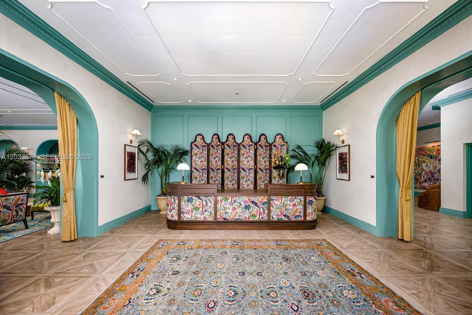 A reception area features a patterned desk, teal wall paneling, arched doorways, and a large rug — 2700 NW 2nd Ave # 237, Miami FL 33127, MIAMI, FL