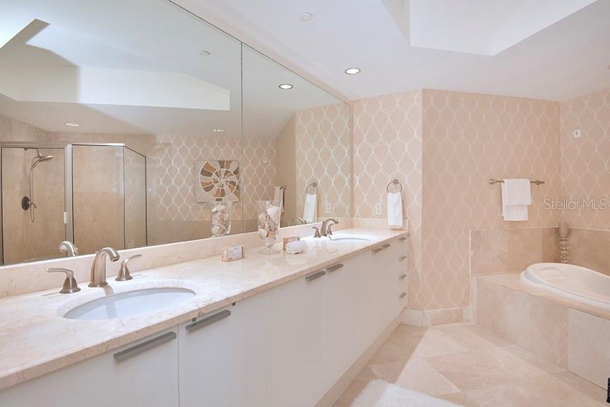 A bathroom features a double vanity with marble countertops, a large mirror, and a bathtub — 231 RIVERSIDE DRIVE UNIT 301-1, HOLLY HILL, FL