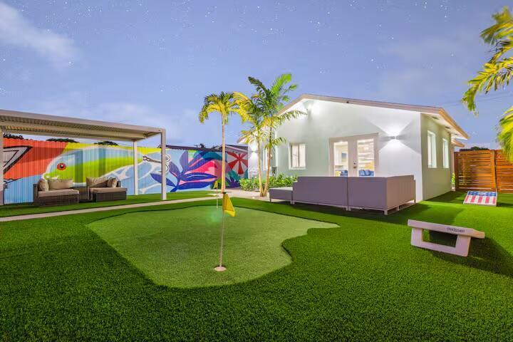 A backyard features a putting green, a mural-covered fence, and a patio with outdoor furniture — 322 NW 4th Avenue, Delray Beach FL 33444, DELRAY BEACH, FL