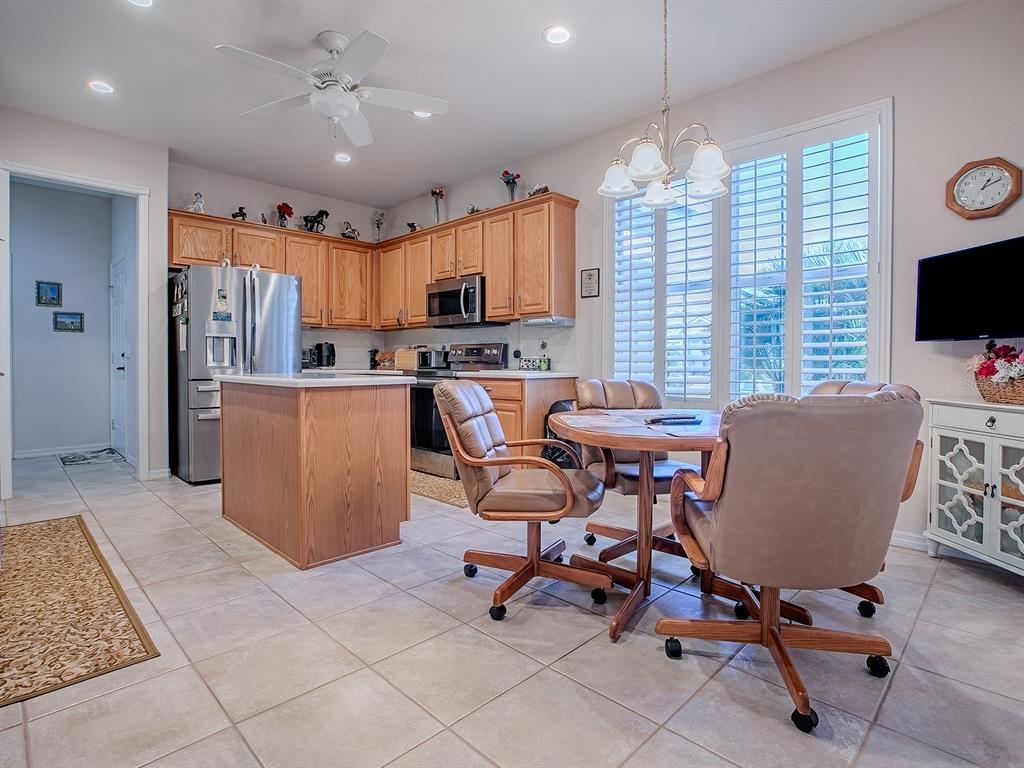 A kitchen and dining area with light wood cabinets, tile floors, and a round table — 13324 SE 91ST COURT ROAD, SUMMERFIELD, FL