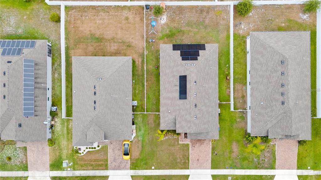 An aerial view shows three suburban houses with shingled roofs and solar panels — 2160 PRESTON LANE, KISSIMMEE, FL