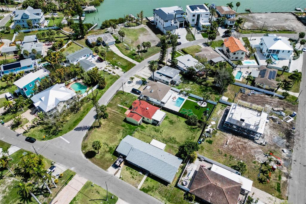 An aerial view shows a residential neighborhood with houses, swimming pools, and waterfront properties — 15822 REDINGTON DRIVE, REDINGTON BEACH, FL