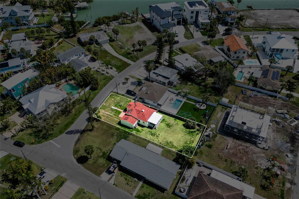 An aerial view shows a house with a red roof on a rectangular lot — 15822 REDINGTON DRIVE, REDINGTON BEACH, FL