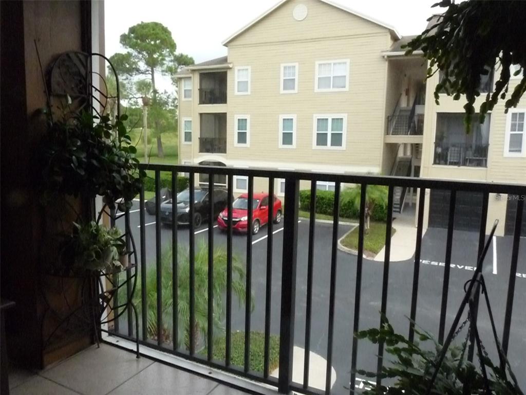A view from a balcony overlooking a parking lot and a multi-story apartment building — 400 SUMMIT RIDGE PLACE UNIT 216, LONGWOOD, FL