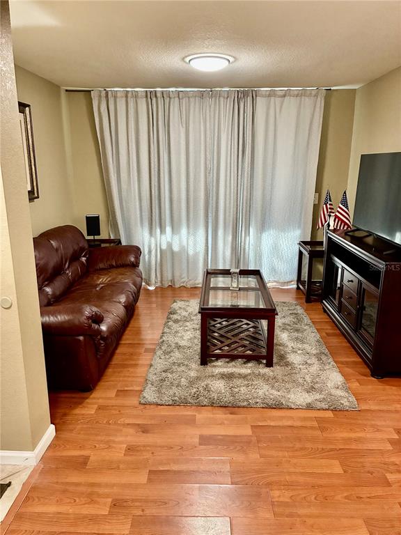 A living room features a brown leather sofa, a glass coffee table, and a television console — 4149 RESIDENCE DRIVE UNIT 801, FORT MYERS, FL