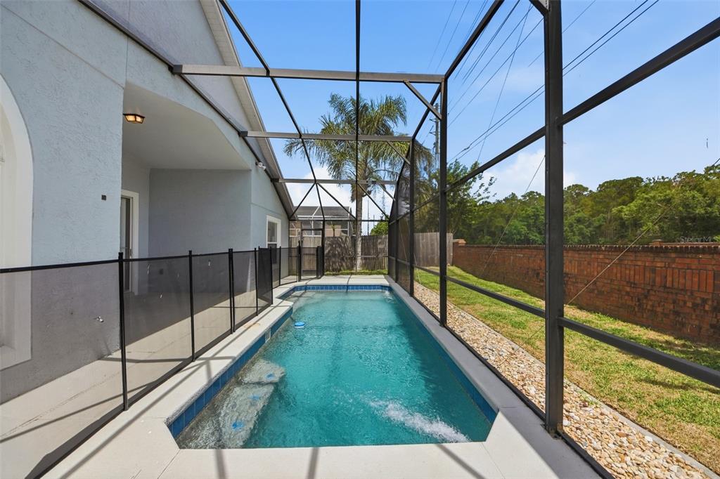 A rectangular swimming pool is enclosed by a screened lanai next to a brick wall — 3724 BECONTREE PLACE, OVIEDO, FL