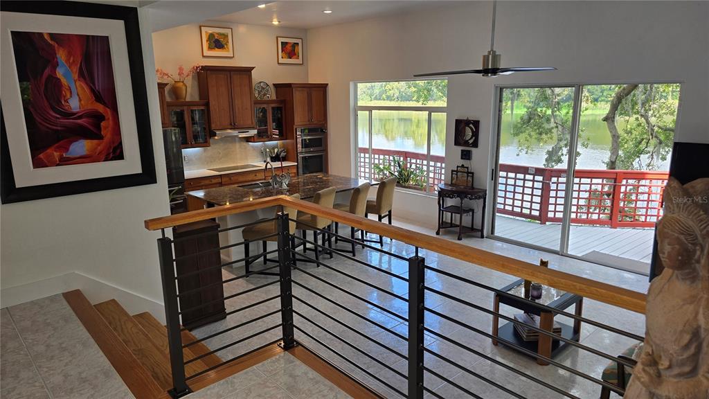 An elevated view of a kitchen and living area overlooking a lake through large windows — 3401 E SLIGH AVENUE, TAMPA, FL