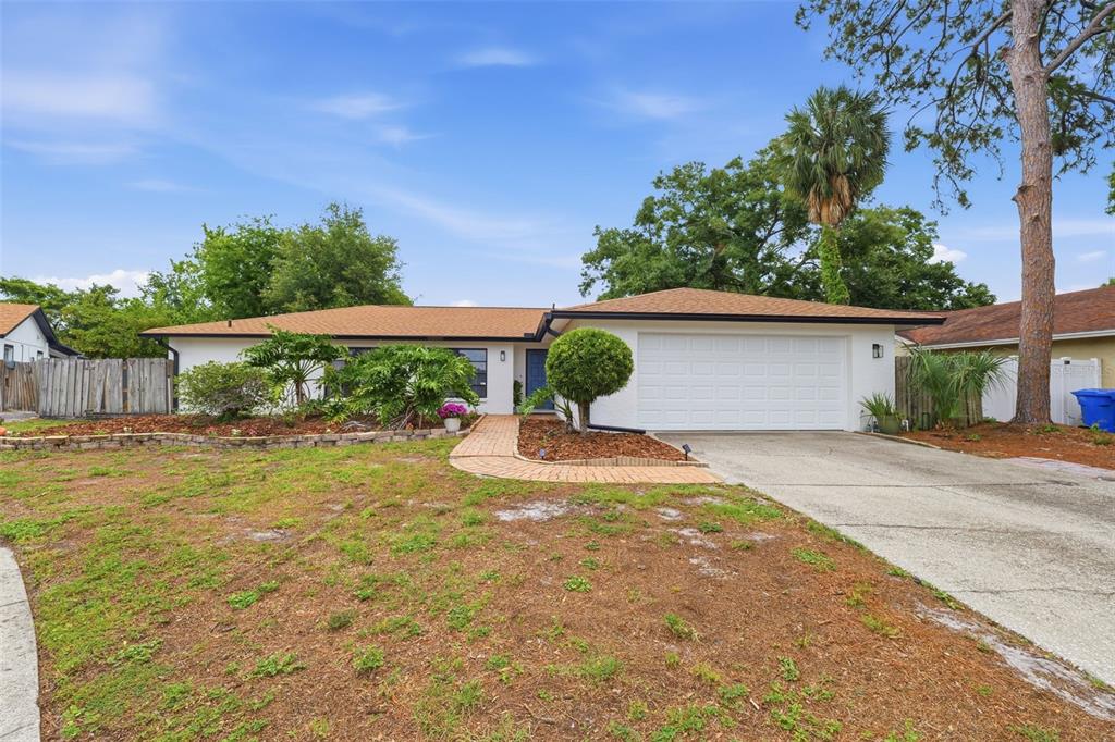 A single-story house with a white exterior, a brown shingled roof, and a two-car garage — 8307 VALLEJO PLACE, TAMPA, FL