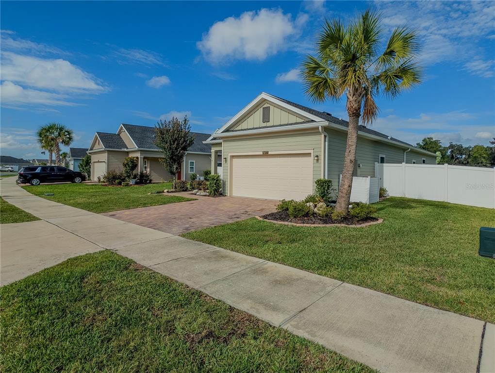 A light green single-story house with a two-car garage and a palm tree out front — 2022 NW 44TH COURT ROAD, OCALA, FL