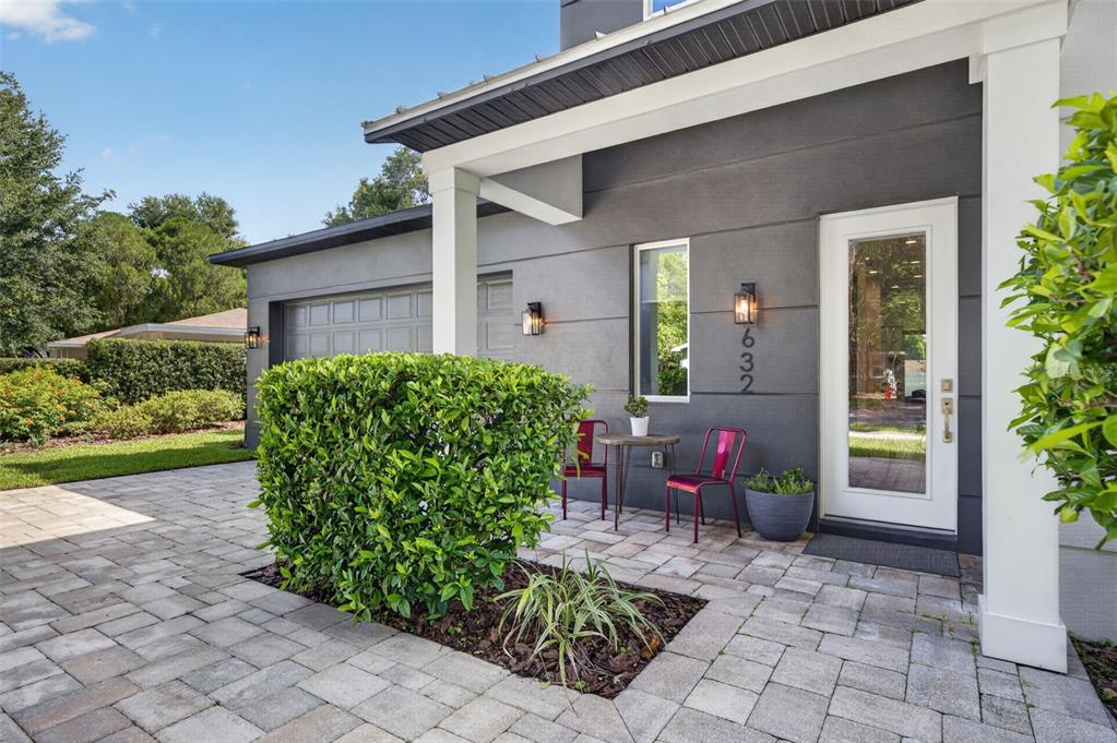 A paved patio area sits in front of a gray house with a white door — 632 GAMEWELL AVENUE, MAITLAND, FL