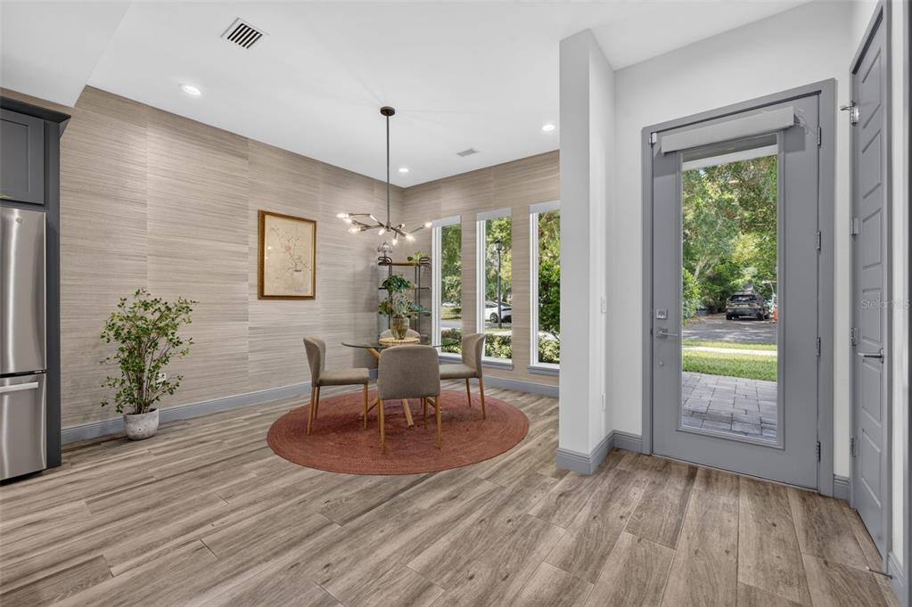 A dining area features wood-look flooring, textured wallpaper, a round table, and a glass door — 632 GAMEWELL AVENUE, MAITLAND, FL