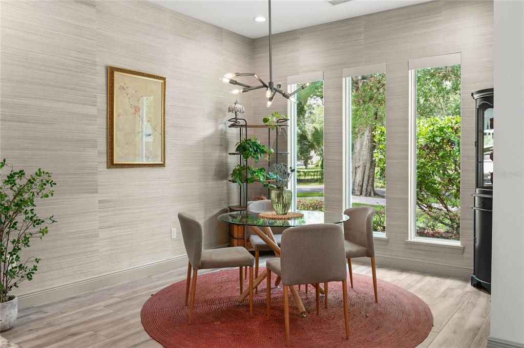 A dining area features a glass table, four chairs, a round rug, and tall windows — 632 GAMEWELL AVENUE, MAITLAND, FL