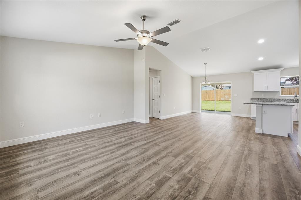 An open-concept living area features light gray walls, wood-look flooring, and a vaulted ceiling — 6762 W CHERRY ROAD, OCALA, FL