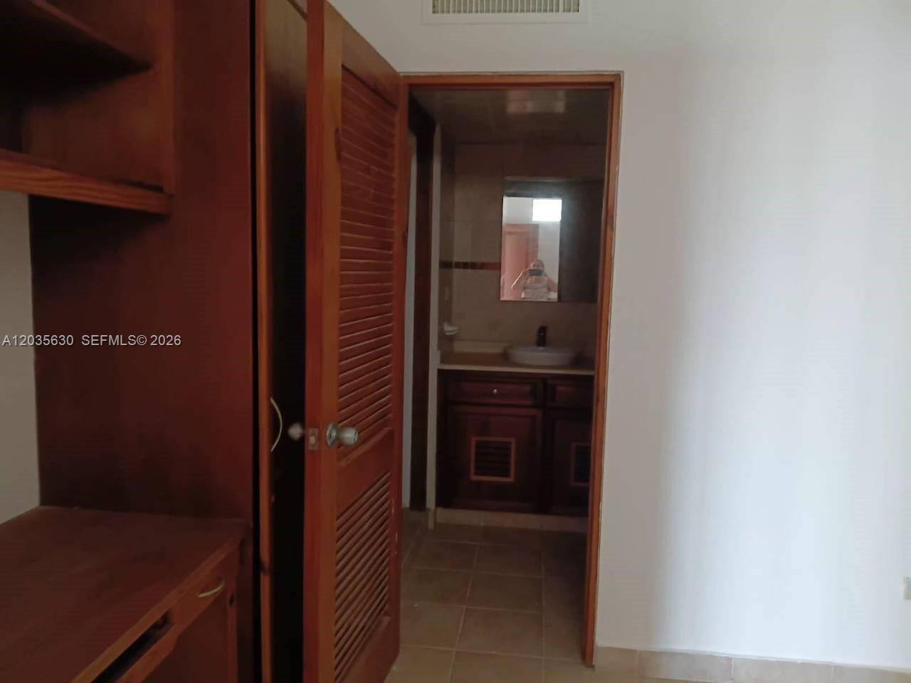 A view from a room looking into a bathroom with a wooden vanity — 1 cap cana # 0, FL