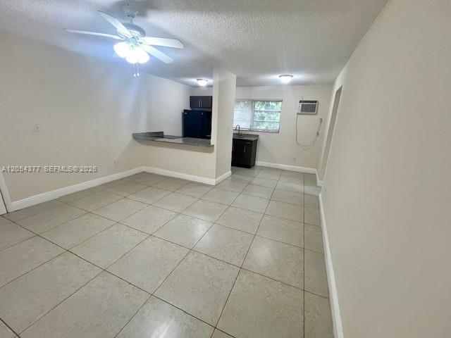 This room features light-colored tile flooring, a ceiling fan, and an open kitchen area — 685 NE 85th St # 2, Miami FL 33138, MIAMI, FL