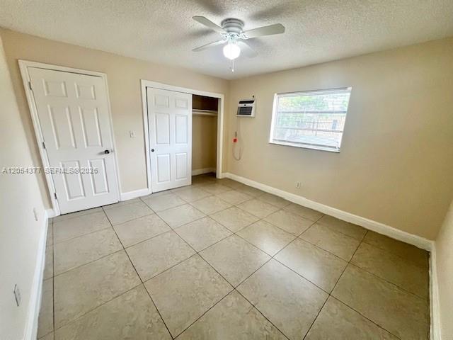 An empty bedroom features beige walls, tile flooring, a ceiling fan, and two white doors — 685 NE 85th St # 2, Miami FL 33138, MIAMI, FL