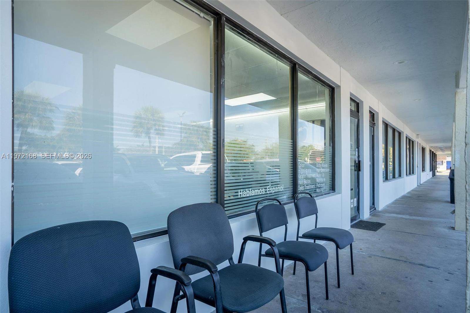 A row of chairs sits on a sidewalk outside a storefront with glass windows — Taft ST, Pembroke Pines FL 33024, PEMBROKE PINES, FL