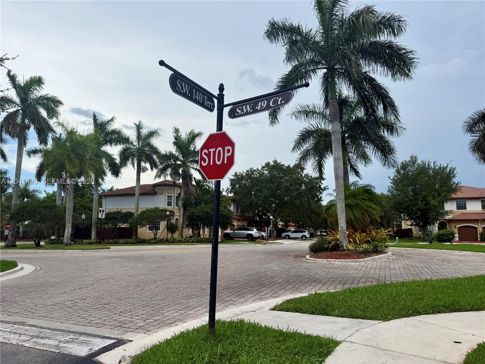 A street sign at an intersection with a stop sign and palm trees in Florida — 14051 SW 49th Ct # 7, Miramar FL 33027, MIRAMAR, FL