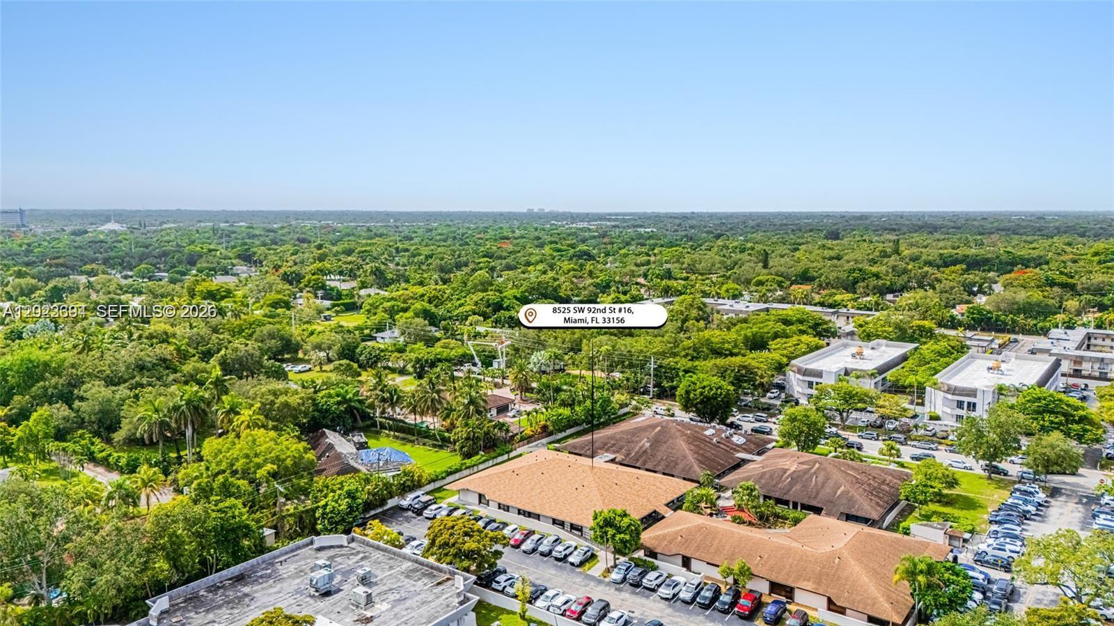 An aerial view shows a low-rise building complex surrounded by dense green trees — 8525 SW 92nd St # 16, Miami FL 33156, MIAMI, FL