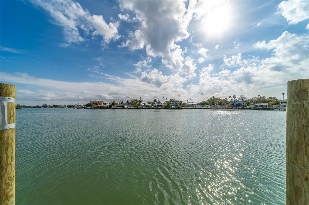 A view of a calm waterway looking toward a shoreline with houses and palm trees — 1217 BAY SHORE BOULEVARD, INDIAN ROCKS BEACH, FL