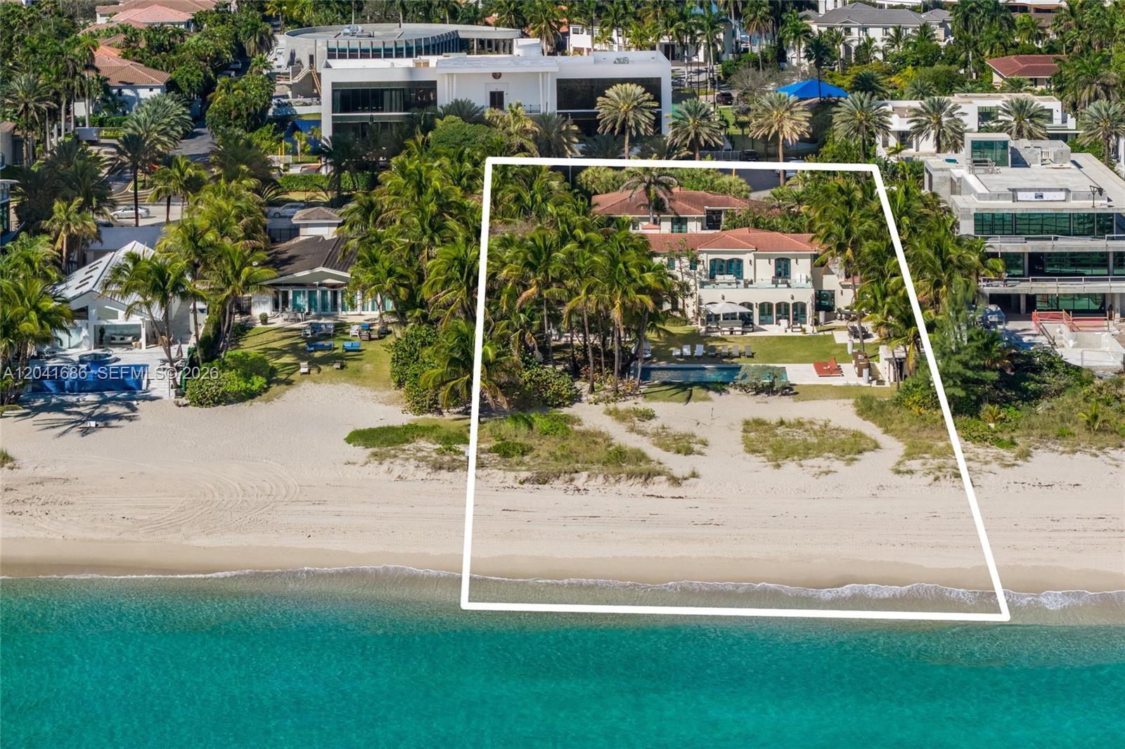 An aerial view shows a beachfront mansion with a pool and palm trees — 115 Ocean Blvd, Golden Beach FL 33160, GOLDEN BEACH, FL