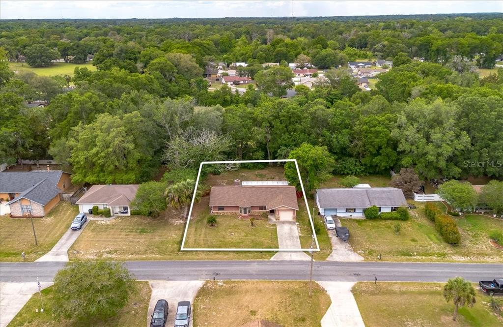 A single-story house with a stone-accented facade, brown roof, and an attached one-car garage — 4760 NE 28TH TERRACE, OCALA, FL