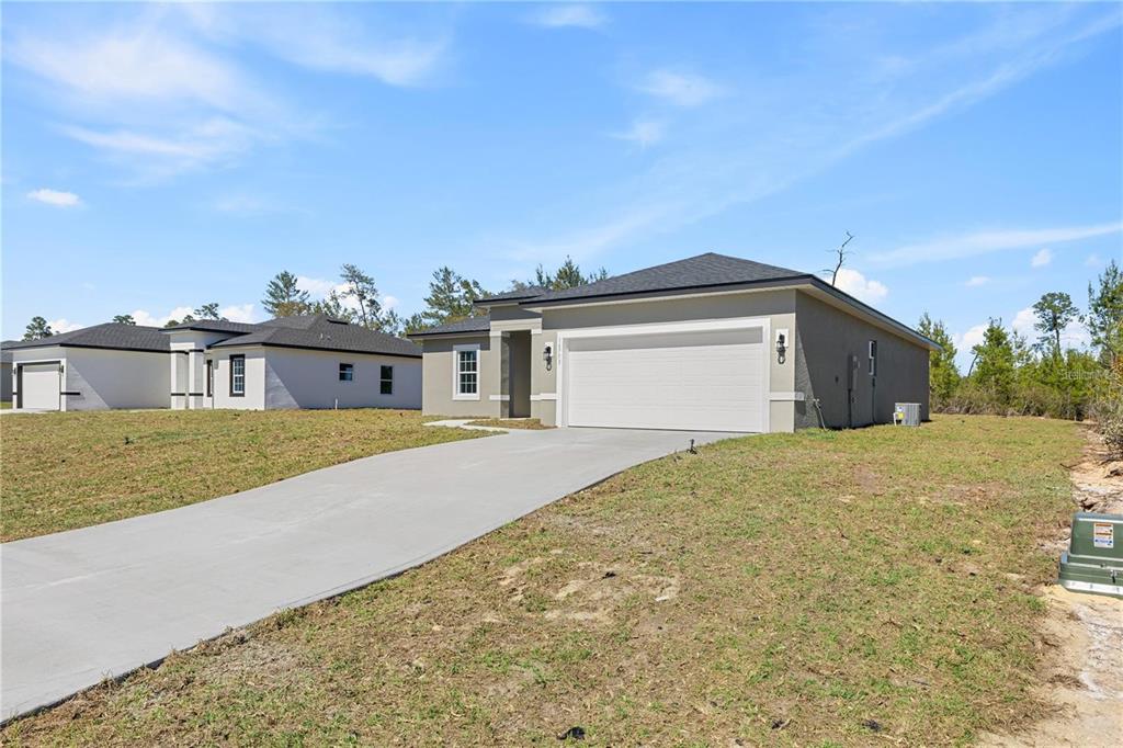 A single-story house with a two-car garage and a concrete driveway sits on a lot — 16753 SW 29TH TERRACE, OCALA, FL