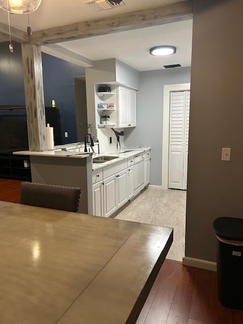 A kitchen with white cabinets, light countertops, and tile flooring viewed from a dining area — 815 W BOYNTON BEACH Boulevard # 202, Boynton Beach FL 33426, BOYNTON BEACH, FL