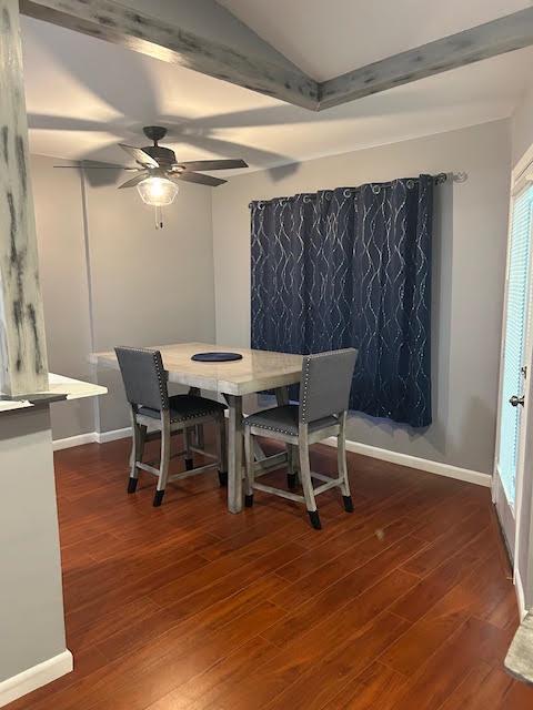 A dining area features a wooden table with two chairs, dark curtains, and wood-look flooring — 815 W BOYNTON BEACH Boulevard # 202, Boynton Beach FL 33426, BOYNTON BEACH, FL
