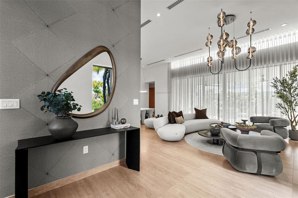 A modern entryway with a console table and mirror leads into a bright, open-concept living room — 63 THE ISLES AT DORADO BEACH, DORADO, PR