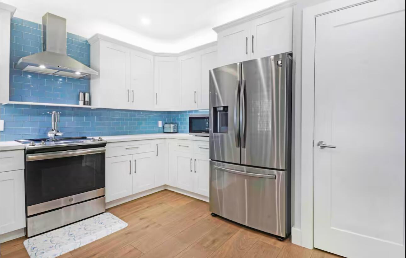 A kitchen with white cabinets, stainless steel appliances, and a blue subway tile backsplash — 623 Jaeger Drive, Delray Beach FL 33444, DELRAY BEACH, FL