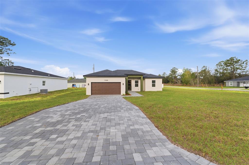 A single-story house with a brown garage door and a paved driveway sits on grass — 15088 SW 51ST AVENUE, OCALA, FL