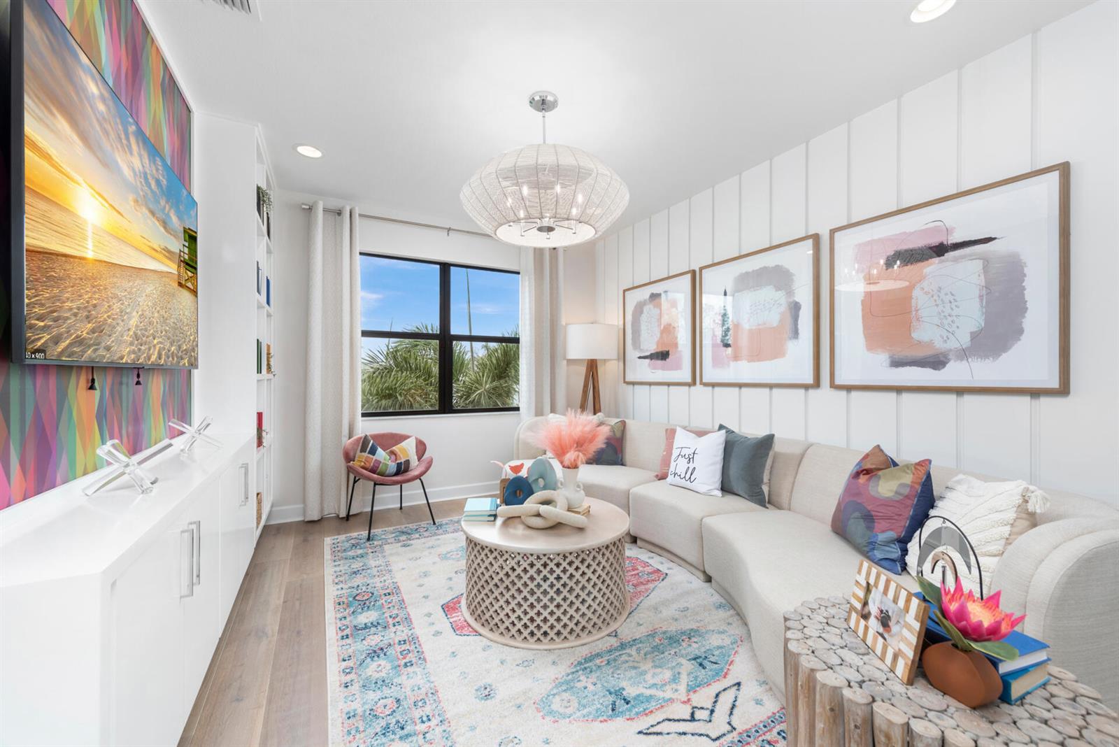 A living room features a curved sofa, patterned area rug, and a wall-mounted television — 419 41st Street, West Palm Beach FL 33407, WEST PALM BEACH, FL