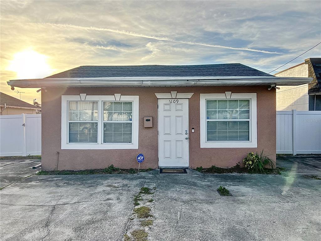 A single-story, tan stucco house with a white front door and two windows — 1109 5TH STREET SW, WINTER HAVEN, FL