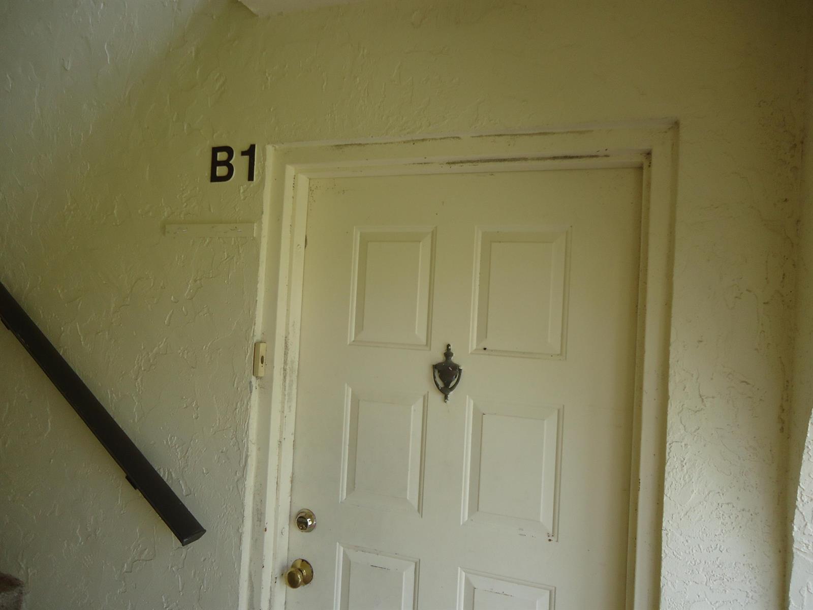 A white door with a knocker and the label B1 on a textured wall — 4731 Sable Pine Circle # B1, West Palm Beach FL 33417, WEST PALM BEACH, FL