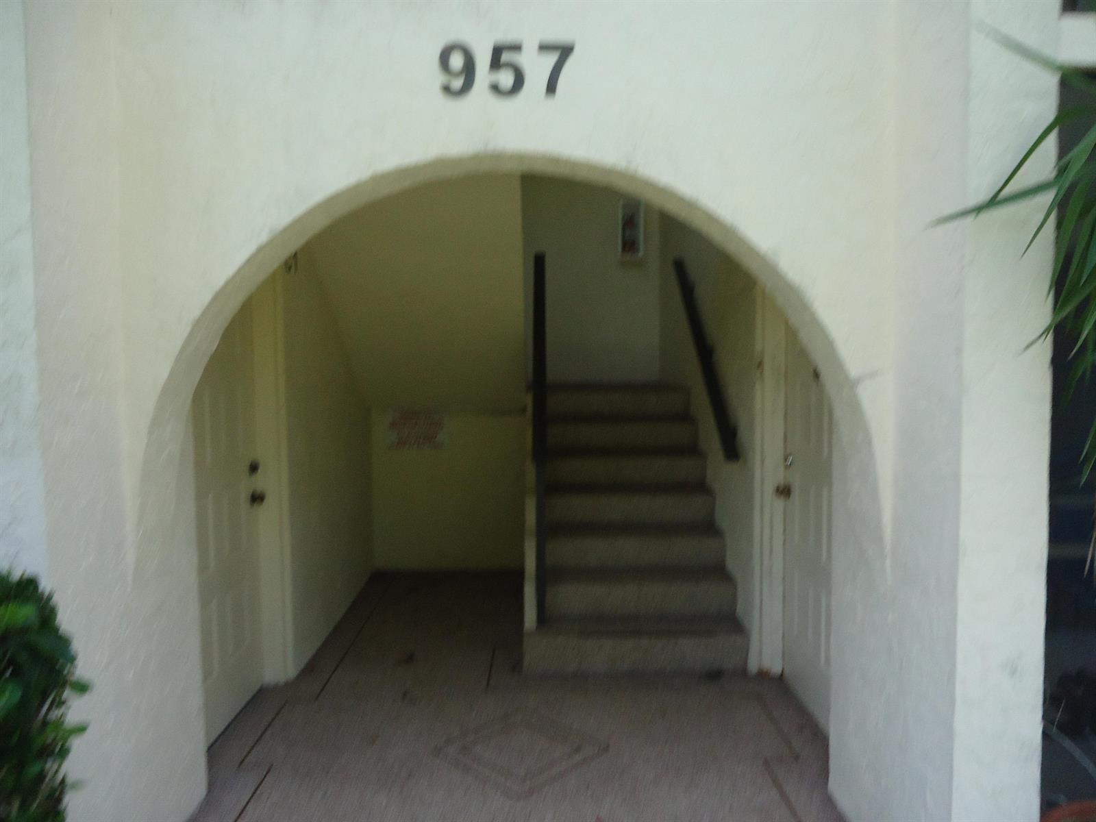 The exterior entrance to a building features an arched entryway with stairs and two doors — 4731 Sable Pine Circle # B1, West Palm Beach FL 33417, WEST PALM BEACH, FL