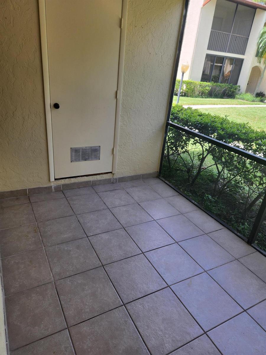 A tiled patio with a screen enclosure and a storage closet door — 4731 Sable Pine Circle # B1, West Palm Beach FL 33417, WEST PALM BEACH, FL