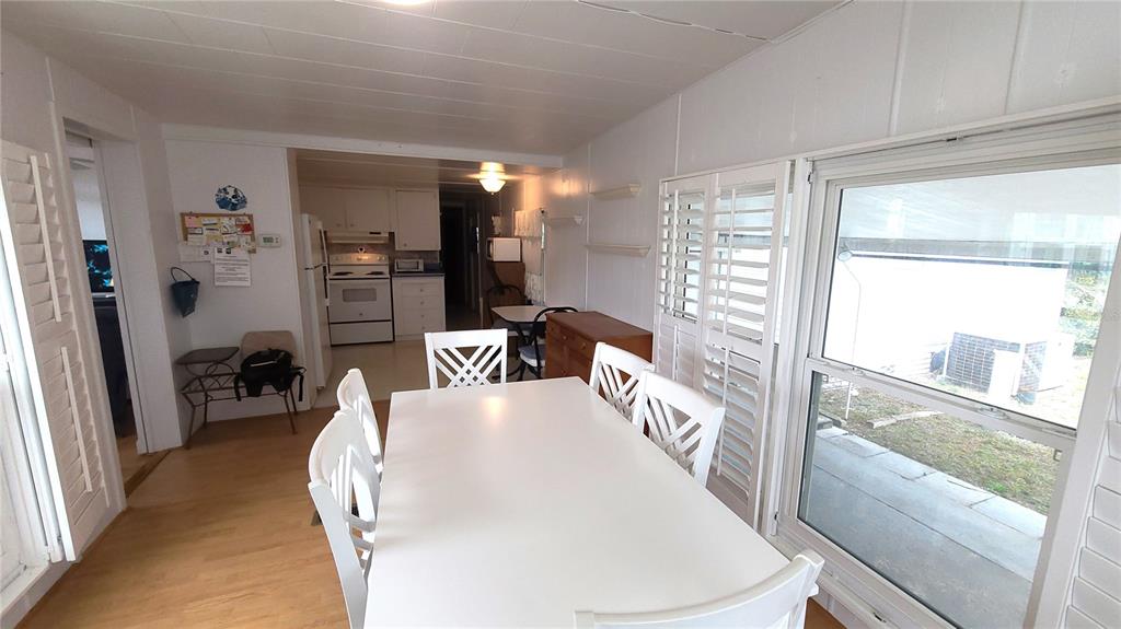 A dining area with a white table and chairs sits adjacent to a kitchen — 4851 W GANDY BOULEVARD UNIT B4 L32, TAMPA, FL