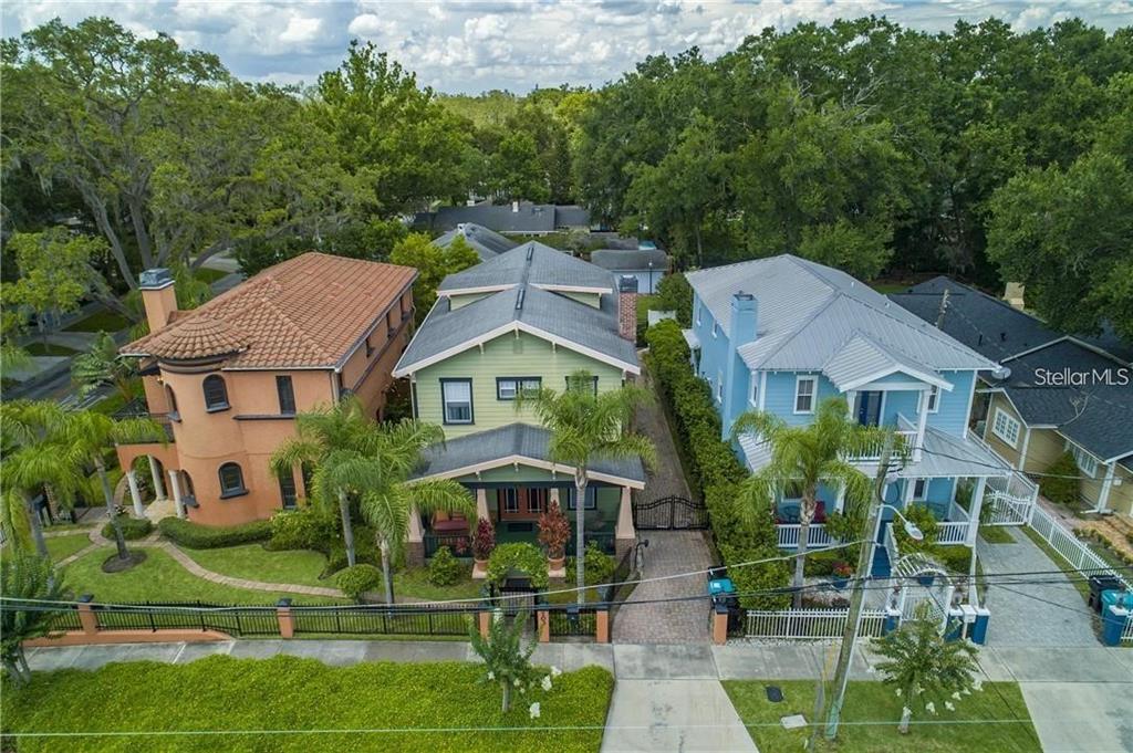 An aerial view shows three colorful houses with palm trees and a shared driveway — 503 N SUMMERLIN AVENUE, ORLANDO, FL