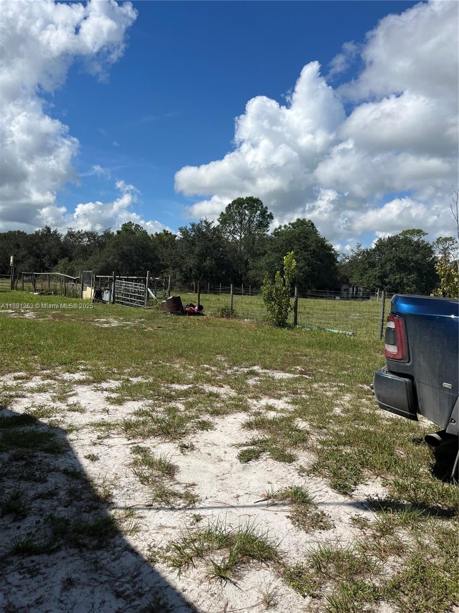 A grassy, sandy lot features a wire fence and a partial view of a truck — 105 Farrer RD, Frostproof FL 33843, FROSTPROOF, FL