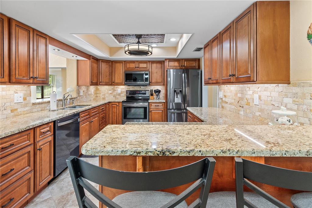 A living room with a beige sofa, two armchairs, a coffee table, and a dining area — 731 CANBERRA ROAD, WINTER HAVEN, FL