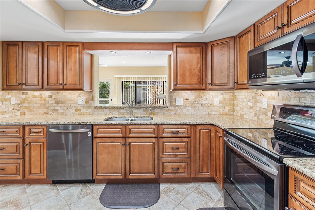 A spacious room with light-colored tile flooring, a ceiling fan, and a wooden display cabinet — 731 CANBERRA ROAD, WINTER HAVEN, FL