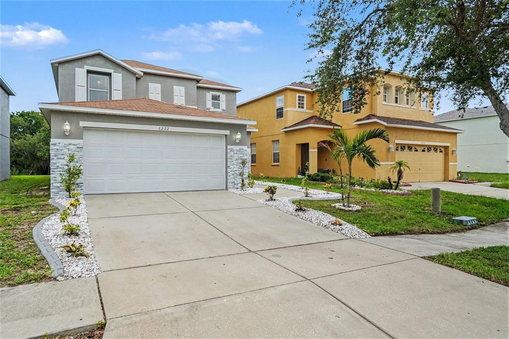 Two suburban two-story houses with driveways and front yards stand side by side — 6222 CHERRY BLOSSOM TRAIL, GIBSONTON, FL