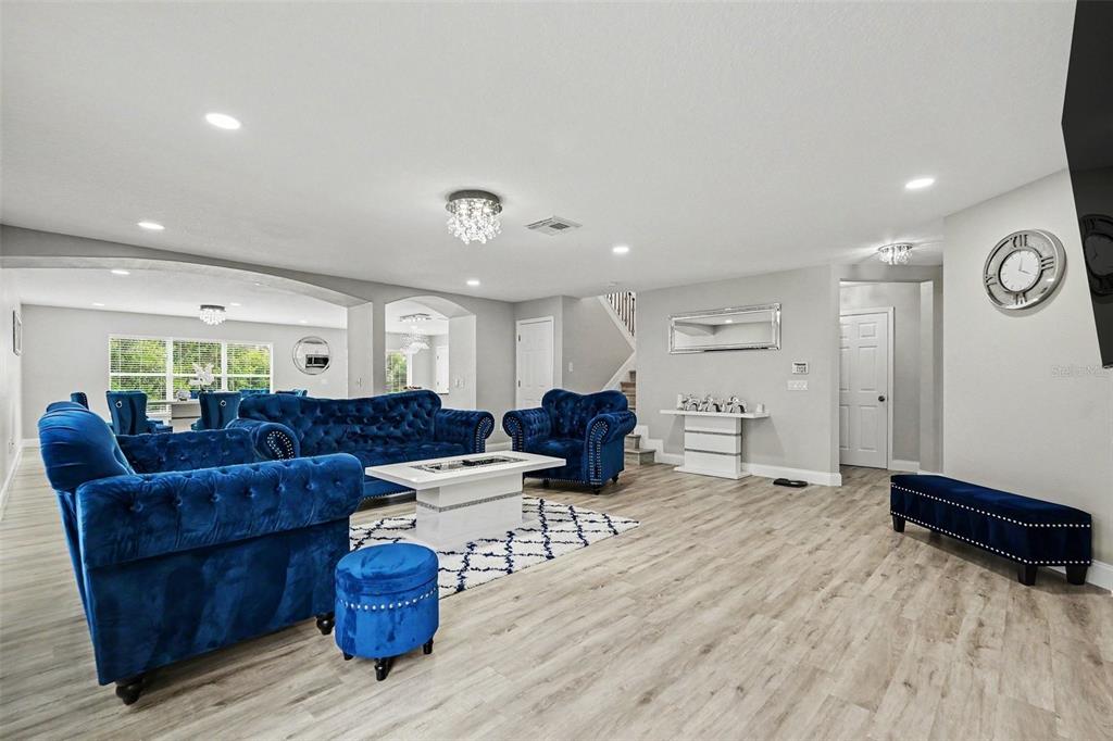 A living room features blue tufted furniture, a white coffee table, and light wood flooring — 6222 CHERRY BLOSSOM TRAIL, GIBSONTON, FL
