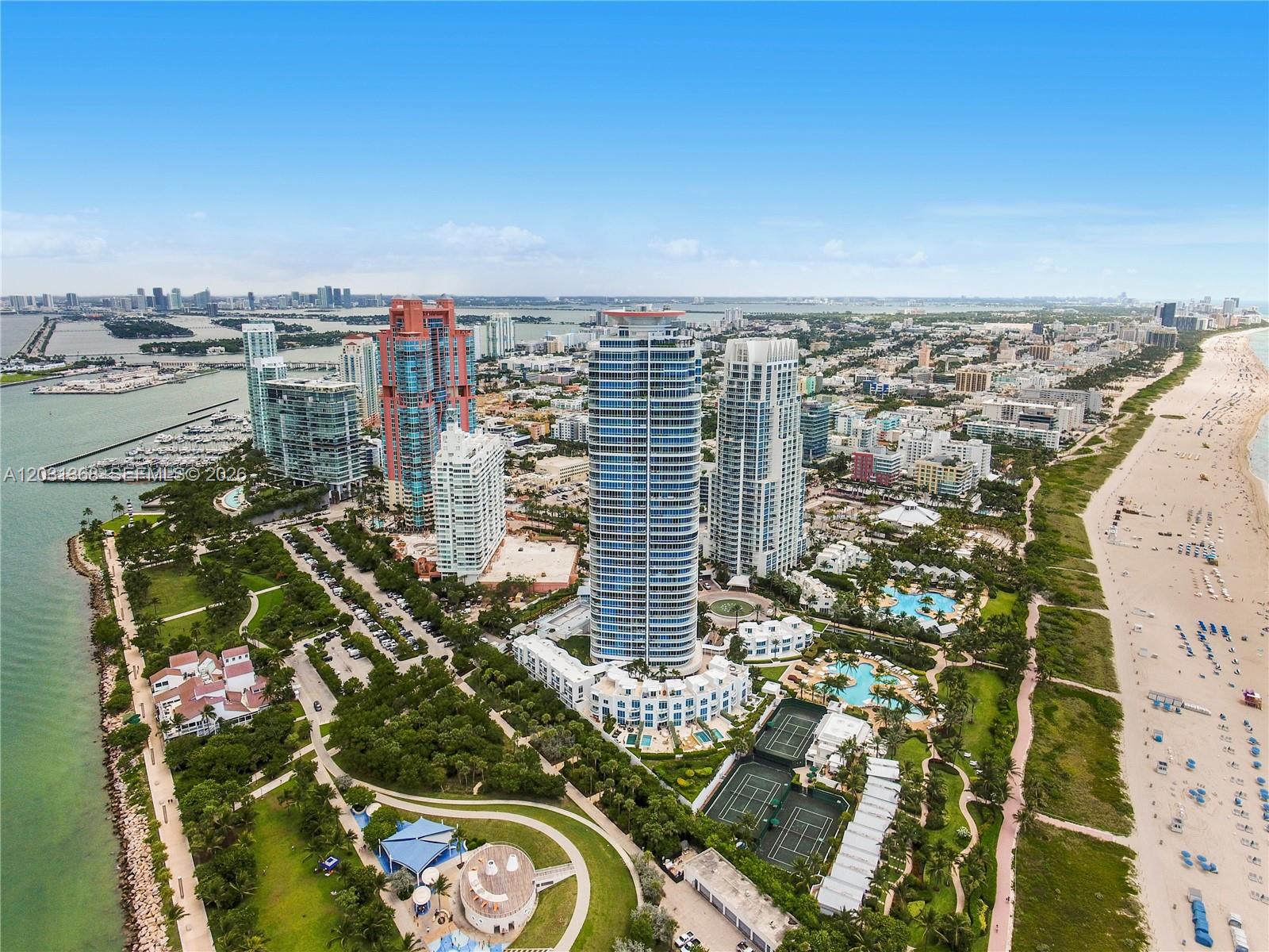 An aerial view of high-rise apartment buildings located along a sandy beach and park — 100 S Pointe Dr # 2806, Miami Beach FL 33139, MIAMI BEACH, FL