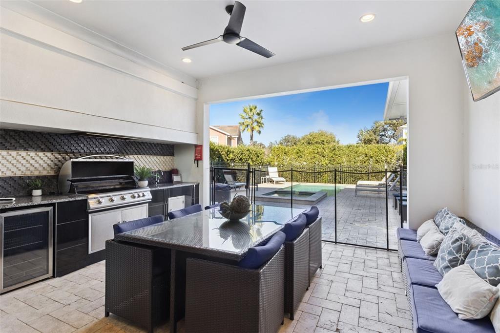 An outdoor patio features a dining set, a built-in grill, and a pool view — 7423 SPARKLING COURT, REUNION, FL